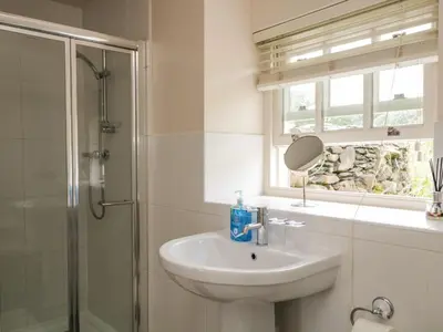 a bathroom with a sink and a shower and a mirror at Lane Head in Grange Over Sands