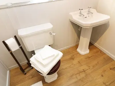 a bathroom with a toilet and a sink at The Hayloft in Grange Over Sands