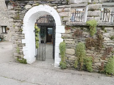 an entrance to a stone building with an arched door at The Hayloft in Grange Over Sands