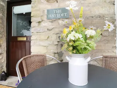 a vase of flowers sitting on a table at The Hayloft in Grange Over Sands