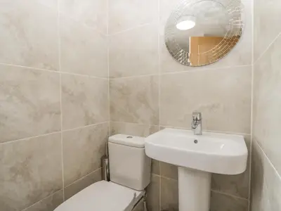 a bathroom with a toilet and a sink and a mirror at Driftwood Cottage Roa Island Piel Island in Barrow in Furness