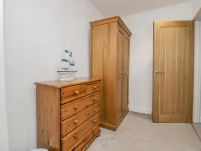 a bedroom with a dresser and a wooden cabinet at Driftwood Cottage Roa Island Piel Island in Barrow in Furness