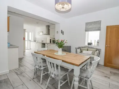 a kitchen and dining room with a wooden table and chairs at Driftwood Cottage Roa Island Piel Island in Barrow in Furness