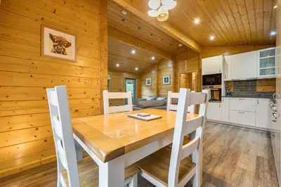 a kitchen and dining room with a wooden table and chairs at Elm Lodge in Ulverston