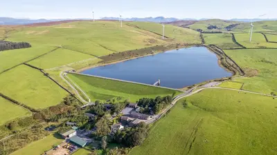 an aerial view of a lake in a field at Elm Lodge in Ulverston