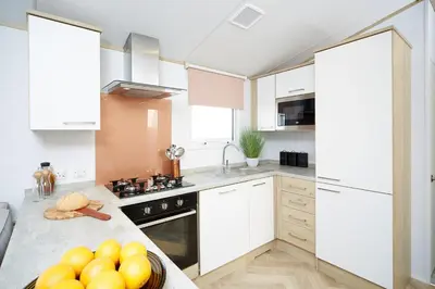 a kitchen with white cabinets and a bowl of fruit on a counter at Mowbreck Park in Kirkham