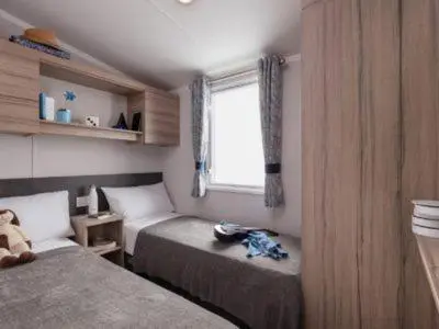 a small bedroom with two beds and a window at Mowbreck Park in Kirkham