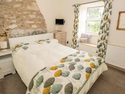 a bedroom with a bed and a window at Herdwick Cottage in Grange Over Sands