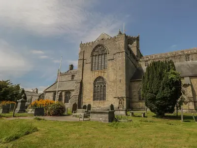 an old stone church with a tree in front of it at Herdwick Cottage in Grange Over Sands