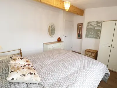 a bedroom with a bed with a white comforter at Foxes Den in Thornton