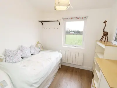 a bedroom with a bed and a window at Foxes Den in Thornton