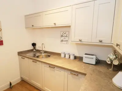 a kitchen with white cabinets and a sink at The Hen House in Thornton