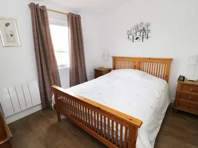 a bedroom with a wooden bed and a window at The Hen House in Thornton