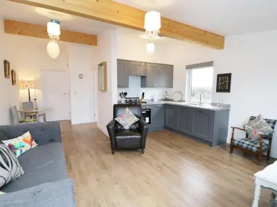 a living room with a couch and a kitchen at The Old Stables in Thornton