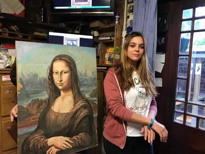 a woman standing next to a painting of a woman at Embassie Backpackers in Liverpool
