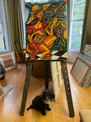 a dog sitting under a table with a painting on it at Embassie Backpackers in Liverpool
