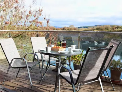 a table and chairs on a deck with a view at Boavista in Carnforth