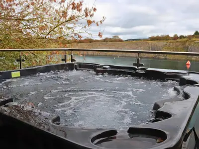a bath tub filled with water next to a body of water at Boavista in Carnforth