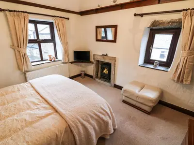 a bedroom with a bed and a fireplace at 1 The Stables in Clitheroe