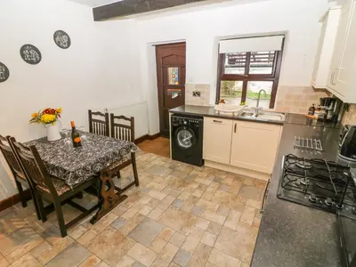 a kitchen with a table and a dining room at 1 The Stables in Clitheroe