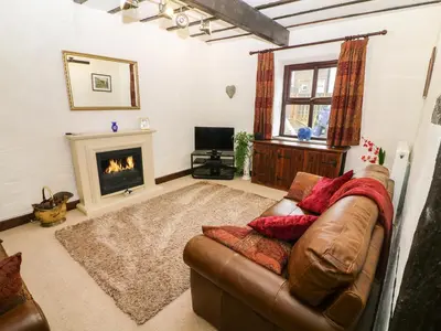 a living room with a couch and a fireplace at 1 The Stables in Clitheroe