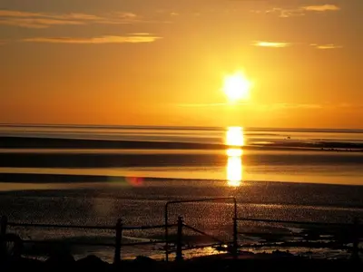 a sunset on the beach with the sun in the sky at Offshore - The Inn Collection Group in Lytham St Annes