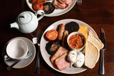 two plates of breakfast food on a wooden table at Offshore - The Inn Collection Group in Lytham St Annes