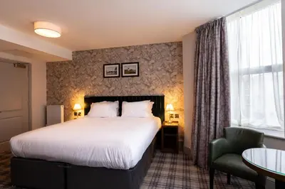 a hotel room with a bed and a chair at Offshore - The Inn Collection Group in Lytham St Annes