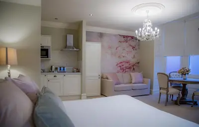 a bedroom with a bed and a table and a kitchen at Winckley Stays in Preston