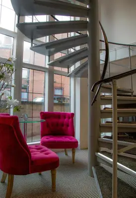 a living room with a red chair and stairs at Winckley Stays in Preston