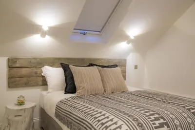 a bedroom with a large bed with a wooden headboard at Winckley Stays in Preston