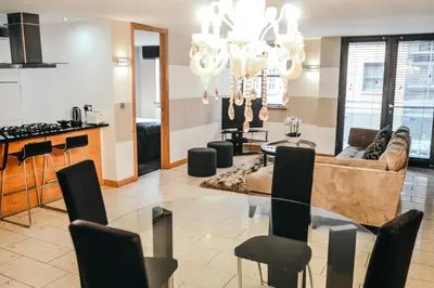 a dining room and living room with a chandelier at Posh Pads - Liverpool 1 - Apart-Hotel in Liverpool