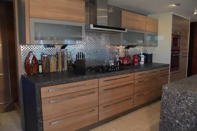 a kitchen with wooden cabinets and black counter tops at Posh Pads - Liverpool 1 - Apart-Hotel in Liverpool