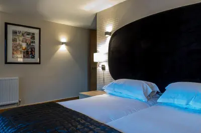 a hotel room with a large bed with blue pillows at Posh Pads - Liverpool 1 - Apart-Hotel in Liverpool