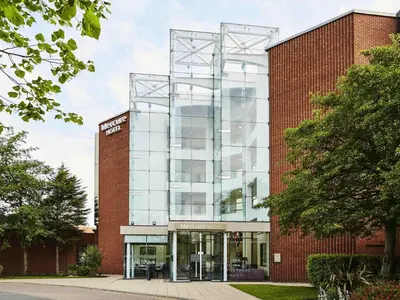 a brick building with a glass facade at Mercure St Helens in Saint Helens
