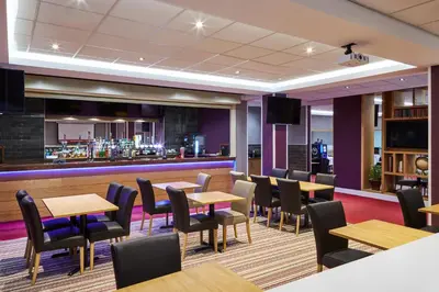 a restaurant with tables and chairs and a bar at Mercure St Helens in Saint Helens