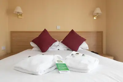 a bed with two towels on top of it at Queens Hotel in Blackpool