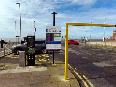 a parking lot with a sign next to a parking meter at Phoenix Guest House in Blackpool