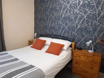 a bedroom with a bed with a blue and white wallpaper at Phoenix Guest House in Blackpool