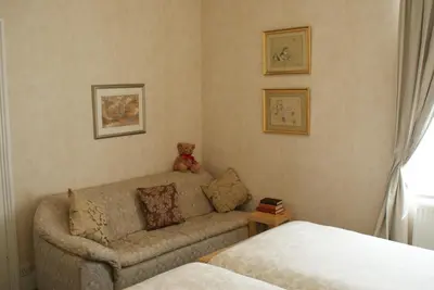 a living room with a couch and a teddy bear at The Norwood Guest House in Southport