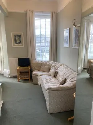 a living room with a couch and a television at The Norwood Guest House in Southport