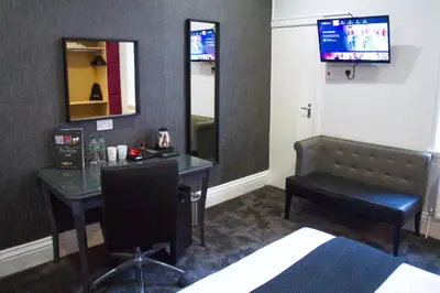 a room with a desk and a chair and a mirror at The Bromley in Blackpool