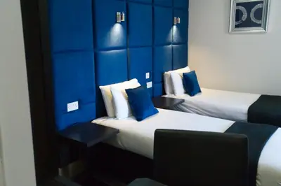 two beds in a hotel room with blue walls at The Bromley in Blackpool