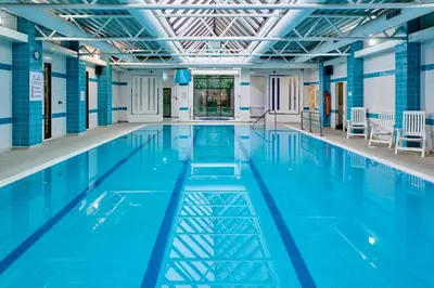 a large swimming pool with blue water at Holiday Inn Haydock by IHG in Haydock