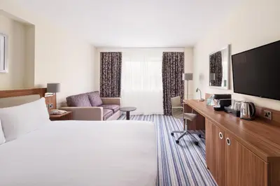 a hotel room with a bed and a flat screen tv at Holiday Inn Haydock by IHG in Haydock
