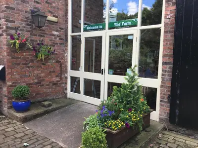 a door to a store with flowers in front of it at The Farm Burscough in Burscough