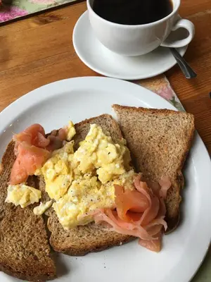 a white plate with a sandwich and a cup of coffee at The Farm Burscough in Burscough