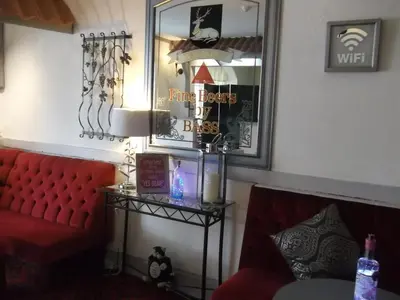 a living room with a red couch and a mirror at Elmfield in Blackpool