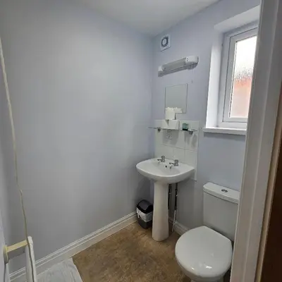a white bathroom with a toilet and a sink at Denville Hotel in Blackpool