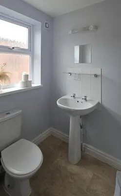 a white bathroom with a toilet and a sink at Denville Hotel in Blackpool